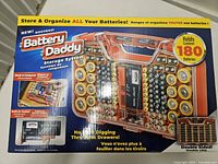 Front of boxed Battery Daddy showing product image and 180-battery capacity