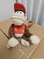 Front view of Diddy Kong plush sitting on cardboard
