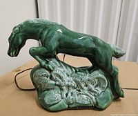 right side view of green ceramic horse lamp on base