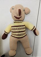 Front view of hand-knitted plush doll showing colors and overall condition