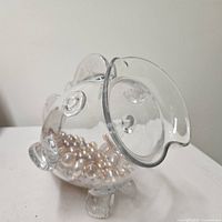 Left side of fish-shaped glass container showing pearlescent bead filler