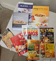 All nine cookbooks and booklets arranged on table