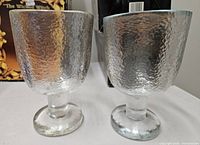 two clear hammered-texture goblets