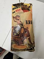 Top view of worn box with graphic of monkey riding elephant and Chinese text