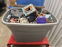 Grey bin filled with assorted Playmobil castle parts