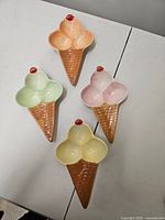 Front view of four pastel ice-cream-cone dishes