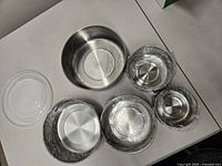 Set of five stainless interior bowls nested, four with protective film, lids visible