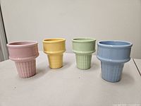 Front view of four colored ceramic ice-cream cone cups
