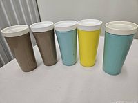 Five tall Twinsulated tumblers with white lids in various colors