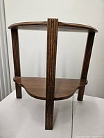 full view of two-tier corner shelf showing fluted legs and shelves