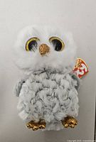 Front view of Ty Beanie Boo Owlette plush showing face, gold beak and eyes, swing tag