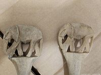 Close-up of elephant carvings on both utensil handles