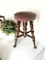 Full view of stool showing wood frame, upholstery, legs, feet