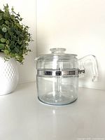 Complete percolator assembled showing glass body, handle and lid