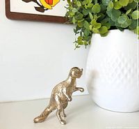 Front view of brass ceratosaurus figurine