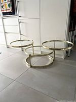 Coffee table with tiers extended showing glass tops and brass frame