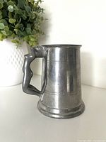 Full view of pewter tankard showing body and nude woman handle