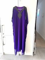 Front view of deep purple embellished kaftan hanging