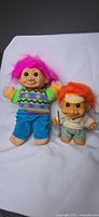 Front view of both Russ troll dolls showing size difference, clothing and hair colors