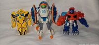 Front view of all three Transformers figures standing upright