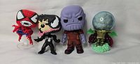 Group shot of four Funko Pop! figures: Spider-Man, Venom, Thanos, Mysterio
