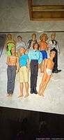 All nine Ken dolls laid out in two rows