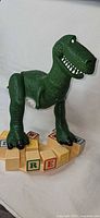 Front view of Rex figure on alphabet block base