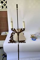 Photo showing the upper section of the Art Deco floor lamp with two candle-style bulb holders and metal detailing.