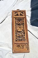 Top view of wood wall decor showcasing carved design and pendant detail