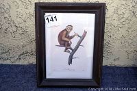 Front view of framed Le Magoto monkey wall art on textured wall background.
