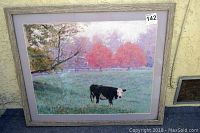 Full shot of the framed original pastel painting showing a black and white cow standing in a field with red trees and fence in background.