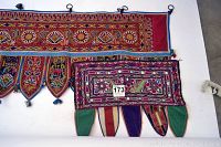 Photo of the two handmade textile wall hangings from India, showing detailed embroidery and colorful fabric panels with pom-poms.