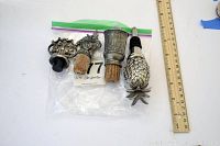 Four decorative wine stoppers arranged with ruler for scale showing their details and sizes.