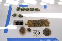 Photo showing the variety of costume stone jewelry items on a white surface with blue tape edges.