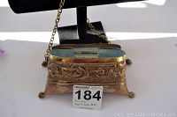 Open view showing the interior and ornate brass top edges with floral engraving.