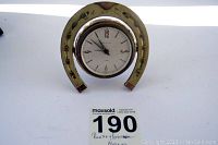 Front view of Rensie horseshoe alarm clock showing clock face and horseshoe detail.