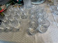 Group of stemmed wine glasses and tumblers on table