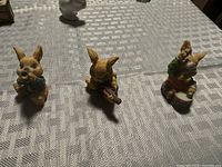 Three painted resin musical rabbit figurines on table