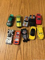 Overhead view of all ten die-cast cars on wood surface