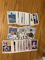 stacks of baseball trading cards spread on wooden surface