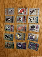 Front view of fifteen holographic Panini NHL team logo stickers arranged in five rows of three