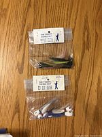 Two sealed packs of bucktail jigs with weight labels visible