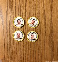 Top-down view of four yellow-rimmed Boston Bruins player coins