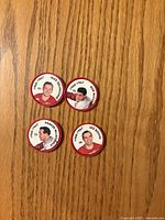 All four Detroit Red Wings player coins shown front side on wood surface