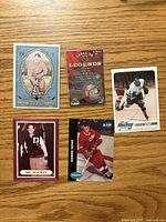 front view of five Gordie Howe items—four cards and a sealed medallion