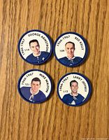 Four Toronto Maple Leafs Shirriff coins laid out on wood surface