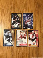 Front view of five oversized Kraft hockey cards laid out on wood surface