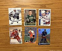Fronts of six Eric Lindros hockey cards on wooden surface