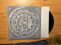 Front cover with gear artwork and BTO logo, portion of record and inner sleeve visible