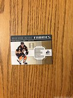 Front of Cam Neely Authentic Fabrics card showing player image and jersey swatch